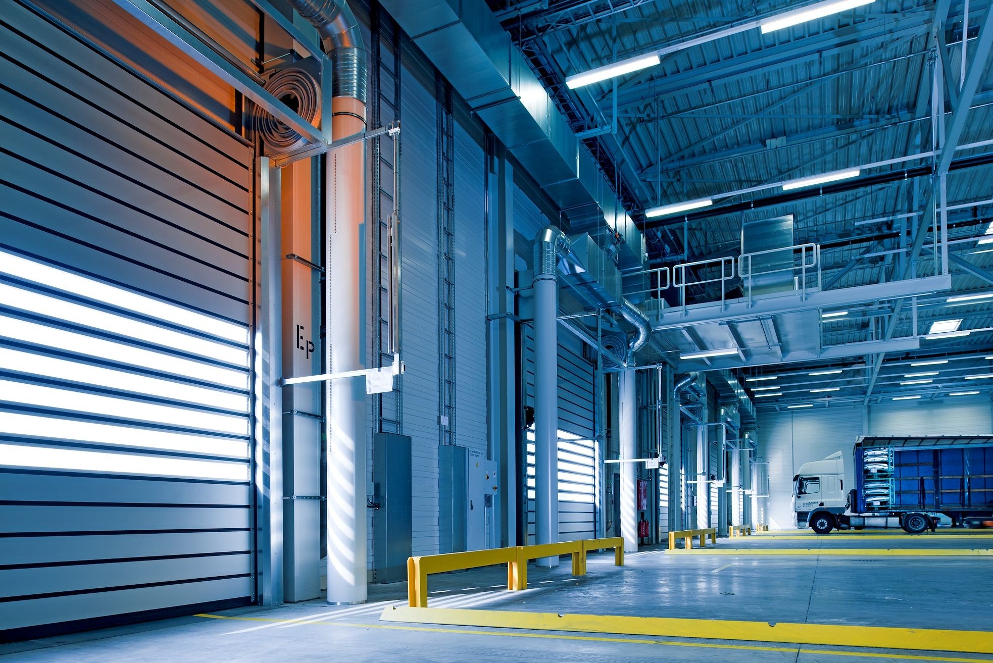 Freight forwarding logistics - a picture of the inside of a warehouse with bay doors.