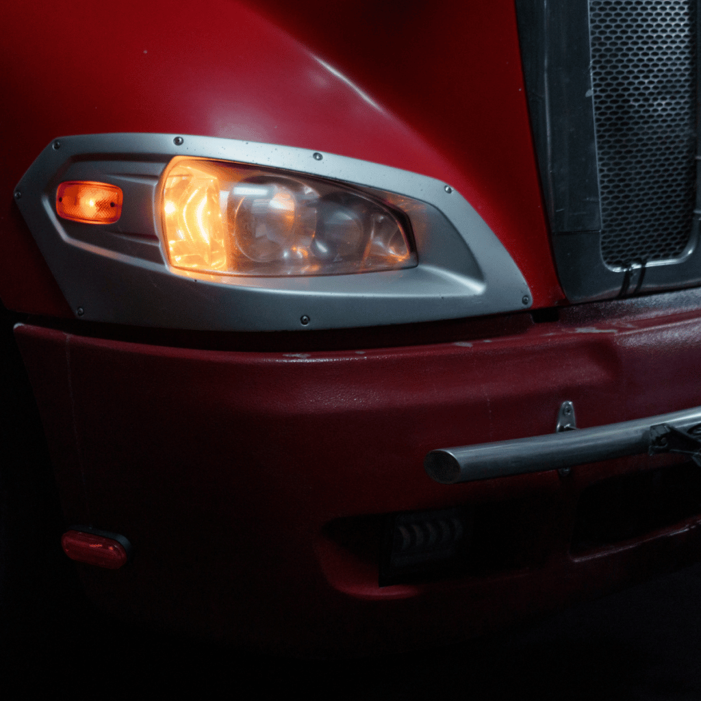 Freight Brokerage - An image of the front of a semi-truck. The headlight and part of the grill. 