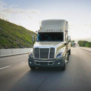 An image of a semi-truck driving down the highway. 